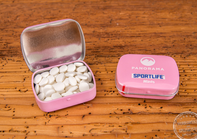 Rosafarbene Klappdeckelbox mit Pfefferminzdragees und Logoaufdruck auf der Vorderseite