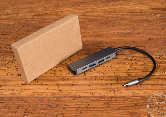 Verpackung des USB-C Hub aus Kraftpapierkarton mit dem USB-C Hub daneben