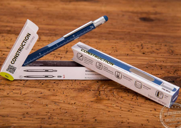 Blauer Troika Construction Multitasking Kugelschreiber mit Werkzeug in Standardverpackung mit Artikelbeschreibung auf Holzplatte.