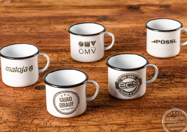 werbemax Emaillebecher mit rusty Optik als Werbegeschenk. 5 Becher auf Holztisch pr&auml;sentiert. 