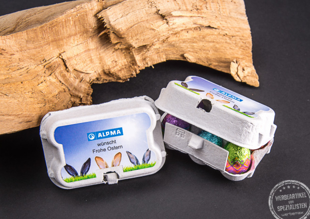 Frohe Ostern Werbebotschaft im kleinen Eierkarton mit bedrucktem Etikett und Schokoeiern