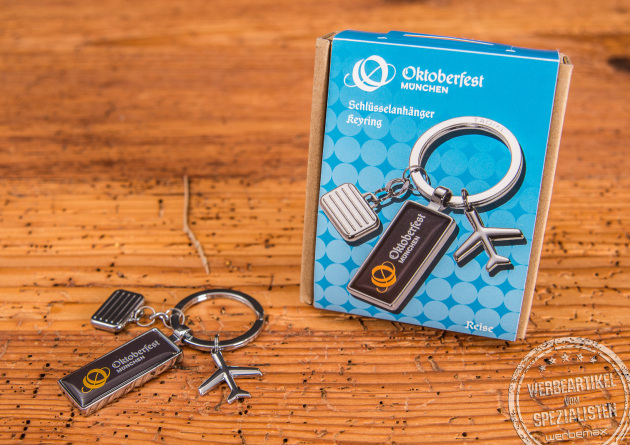 Der Oktoberfestschl&uuml;sselanh&auml;nger ist ein perfektes bayerisches Werbegeschenk zur Wiesn. Der Anh&auml;nger mit Koffer, Flugzeug und dem Oktoberfestlogo ist perfekt f&uuml;r Gesch&auml;ftskunden, die w&auml;hrend der Wiesnzeit in M&uuml;nchen sind. Der Schl&uuml;sselanh&auml;nger kommt im sch&ouml;nen Karton mit Papierbanderole