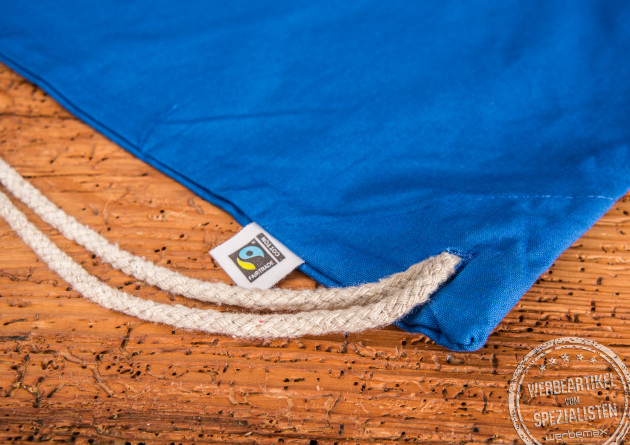 Nahaufnahme vom blauen Turnbeutel Hanna aus Fairtrade Baumwolle. Detailansicht des Fairtrade-Labels. 