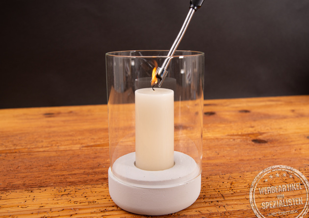 Eine brennende Kerze, die mit einem FutureEcoFlex Lichtbogen Feuerzeug Werbeartikel angez&uuml;ndet wird.