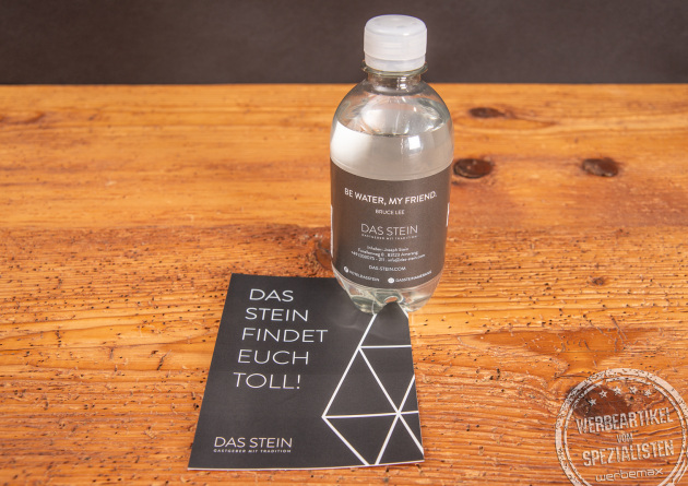 Eine Werbewasserflasche mit individuellem Etikett auf einer passenden Werbekarte stehend.