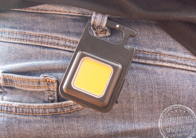 Ein wiederaufladbares Worklight hängend an einer Jeanshose.
