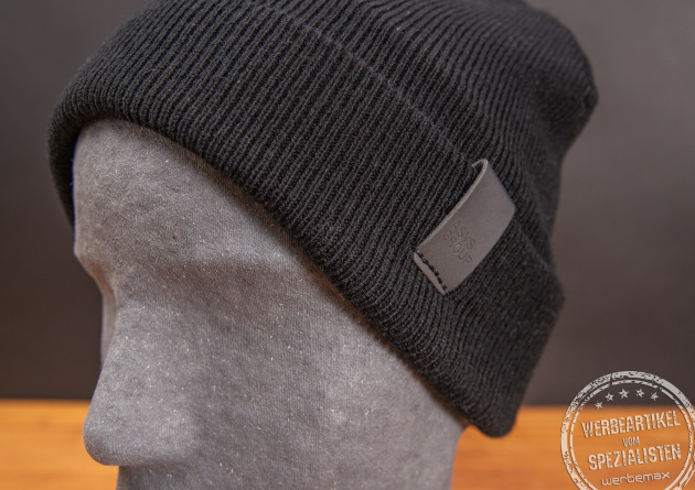 Schwarze Beanie mit schwarzem PU-Patch als Werbeartikel.