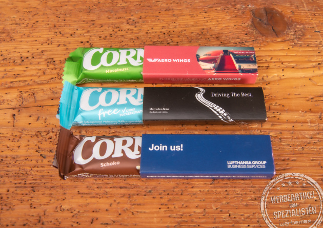 Corny M&uuml;sliriegel im bedruckten Werbeschuber als g&uuml;nstiger Streuartikel f&uuml;r Messen und Seminare