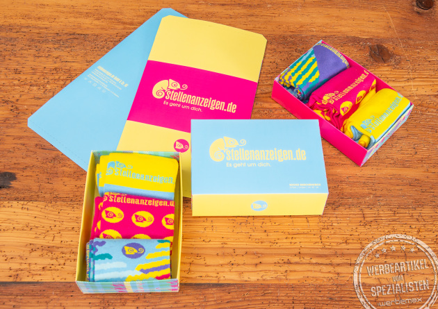 Knallig bunte Werbesocken in individuell gestalteter Werbe-Geschenkbox als Onboarding-Geschenk.