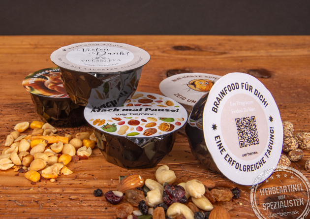 Schwarze nuts-box Nussmischungen mit individuellem Deckel als Giveaway.