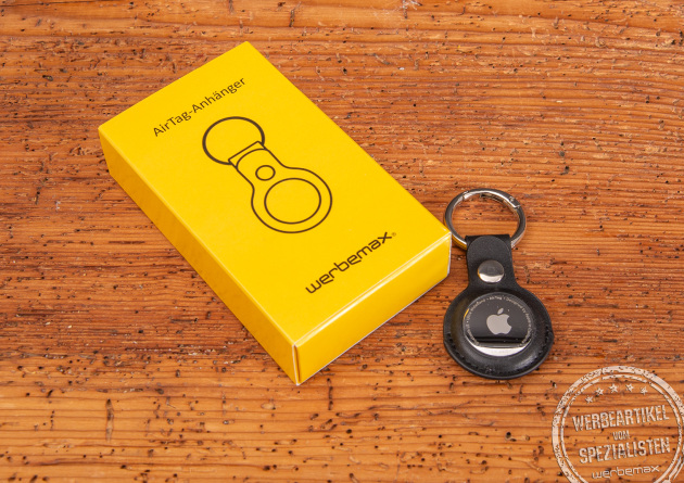 Apple AirTag mit edlem schwarzen Schl&uuml;sselanh&auml;nger als hochwertiges Werbegeschenk auf Holztisch &ndash; praktische Geschenkidee mit Logo f&uuml;r Kunden oder Mitarbeiter, ideal zum Wiederfinden von Schl&uuml;sseln und Taschen.
