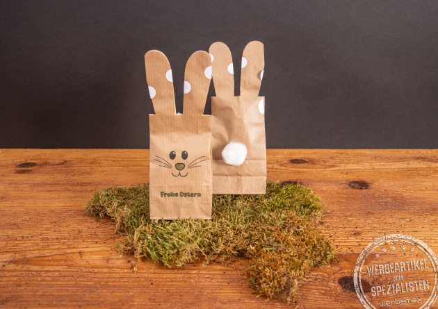 S&uuml;&szlig;e Osterhasen-S&uuml;&szlig;igkeitent&uuml;te Bunny Bag als Mitarbeitergeschenk auf Holztisch.