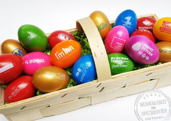Ein schöner Korb voll bunter Ostereier bedruckt mit verschiedenen Logos - auffällig und farbenfroh zu Ostern werben