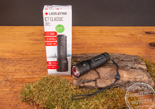 Fachhandelsverpackung der LEDLenser Classic C7 aus Karton mit Sichtfenster. Daneben liegt die Taschenlampe selbst. Klein, kompakt aber unglaublich Leistungsstark.