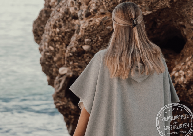 Rückenansicht des Badeponcho in Grau. Mit Kapuze und Logoveredelung. 