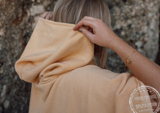 Detailaufnahme der Frottierkapuze des Bade Poncho mit Logo in rose. 