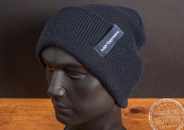 Coole Strickmütze mit Logo als Weblabel an der Seite aufgenäht. Finden Sie Ihre passende Mütze als Werbegeschenk. Im schönen Marine passt das Winteraccessoire gut zu vielen Looks. 