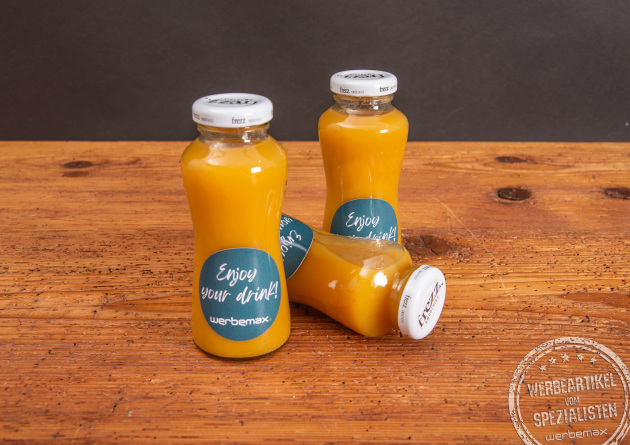 Drei Glasflaschen mit gelbem Smoothie und individuellem Werbe-Etikett als Giveaway.