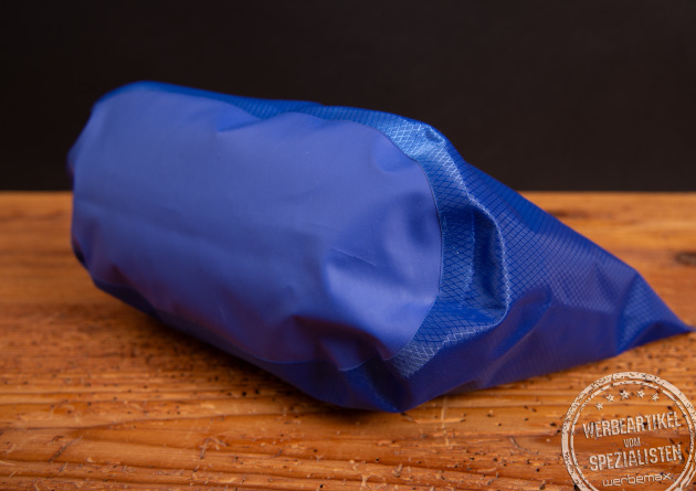 Liegend fotografierte Halfar Drybag 3L in Royalblau auf Holztisch.