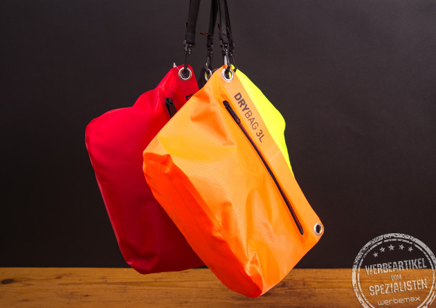 Drei bunte Drybags in Rot, Orange und Neongelb hängend nebeneinander präsentiert.