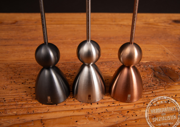 Clack Eierk&ouml;pfer von take2 im Farbvergleich &ndash; Schwarz, Silber und Kupfer auf Holzoberfl&auml;che.