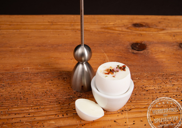 Clack Eierk&ouml;pfer mit ge&ouml;ffnetem Ei im wei&szlig;en Eierbecher &ndash; pr&auml;ziser Schnitt durch Edelstahlmechanik.