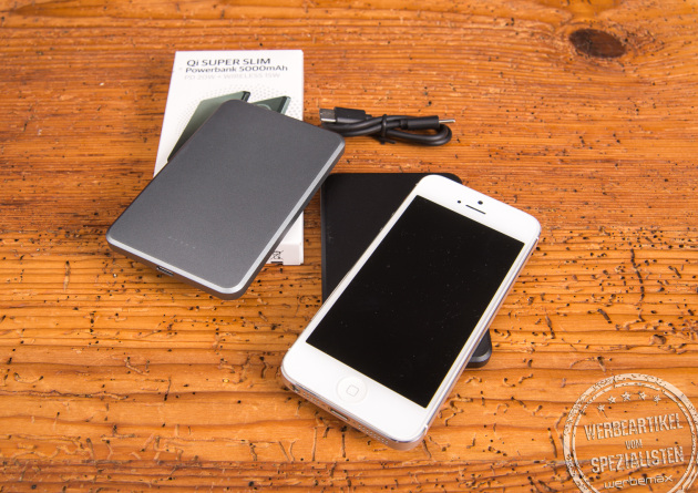 Qi Super Slim Powerbank als Werbeartikel – Set mit Smartphone, USB-Kabel und Verpackung auf Holztisch