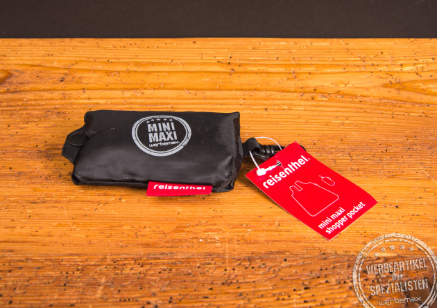 Kompakt verpackter reisenthel Mini Maxi Shopper Pocket in Schwarz mit Logo &ndash; praktische faltbare Tasche als Werbegeschenk bei werbemax.
