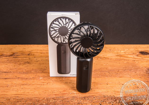 Schwarzer Handventilator Breezy als Werbeartikel mit Logo, vor der passenden Einzelverpackung präsentiert – modernes Sommer-Werbegeschenk.
