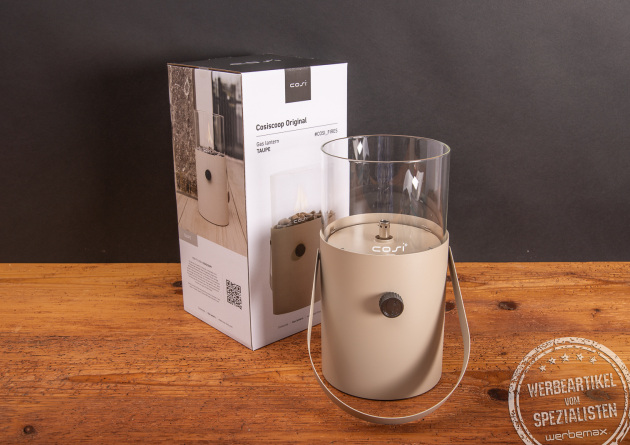 Cosiscoop Original Gaslaterne in Beige mit Verpackung auf Holztisch – elegantes Outdoor-Licht als hochwertiger Werbeartikel mit Logo