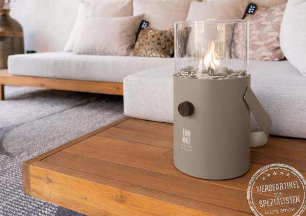 Elegante Gaslaterne der Marke Cosi als Tischfeuer auf einem Holztisch im modernen Wohnzimmer – stilvolles Wohnaccessoire und hochwertiger Werbeartikel mit Logo.