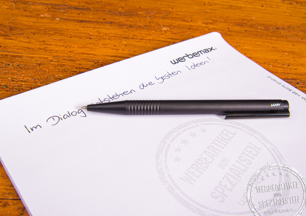 LAMY Logo Black Kugelschreiber beim Schreiben auf Notizpapier – edler Werbeartikel mit Logo-Gravur.