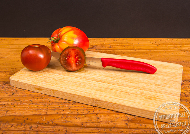 Victorinox Tomatenmesser in Rot mit Tomaten auf Schneidebrett &ndash; Werbemesser mit personalisierter Gravur.