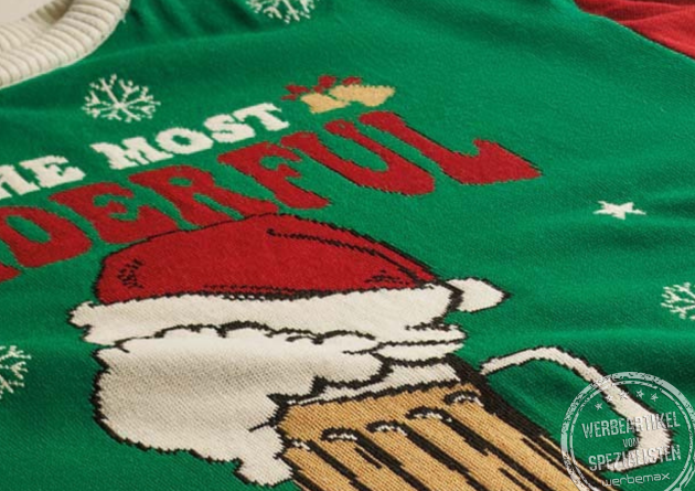 Detailaufnahme eines grünen Ugly Christmas Sweaters mit Bierkrug-Motiv, Santa-Mütze und Schneeflocken im Jacquard-Strick.