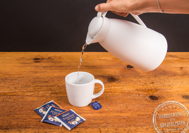 Weiße alfi Isolierkanne ECO beim Einschenken von Tee in eine Tasse – stilvolles Werbegeschenk für Büro und Mitarbeiter.