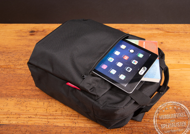 Reisenthel Rucksack Allday Backpack in Schwarz mit Tablet und Büchern – moderner, funktionaler Rucksack aus recyceltem Material als nachhaltiges Geschenk für Mitarbeiter oder Kunden.