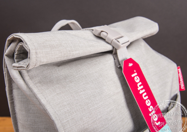 Detailaufnahme des Reisenthel Urban Rolltop Rucksacks in Grau mit Rollverschluss und Logoanhänger – nachhaltiger Design-Rucksack aus recyceltem Material als moderner Werbeartikel oder Mitarbeitergeschenk.