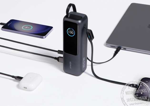 Anker Powerbank 25.000 mAh beim gleichzeitigen Laden mehrerer Geräte, darunter Smartphone, Laptop und Kopfhörer, mit integriertem Kabel und Echtzeit-Display.