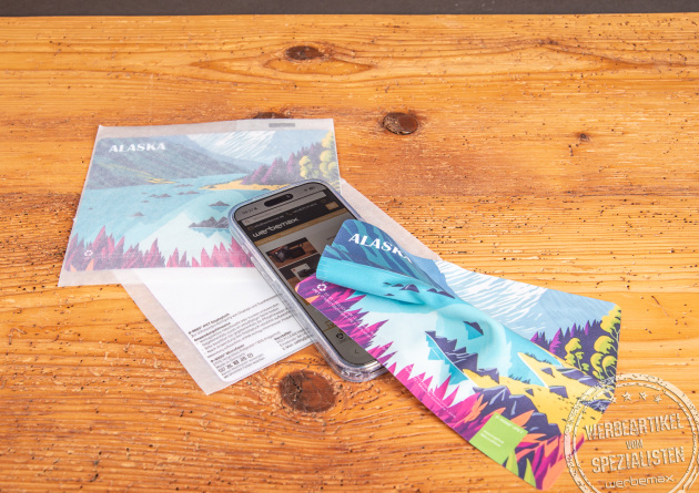 Microfasertuch mit Logo reinigt Touchscreens streifenfrei auf Smartphone und Einlegekarte als nachhaltiger Werbeartikel.