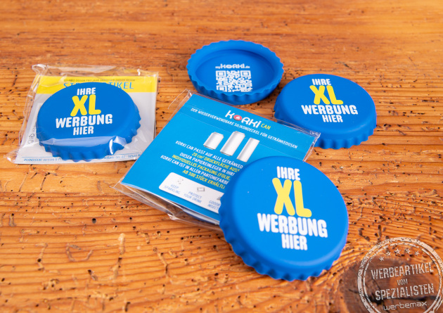 Korki Can Silikon-Dosendeckel als bedruckbarer Werbeartikel in Blau, mehrere XL-Dosendeckel und Verpackung auf Holztisch.
