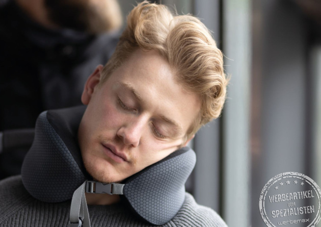 Anwendung des TROIKA Business Travel Pillow als Nackenkissen im Flugzeug zur Nackenentlastung
