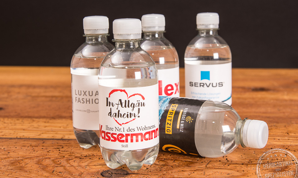Fünf Wasserflaschen mit individuellem Etikett als Werbeartikel