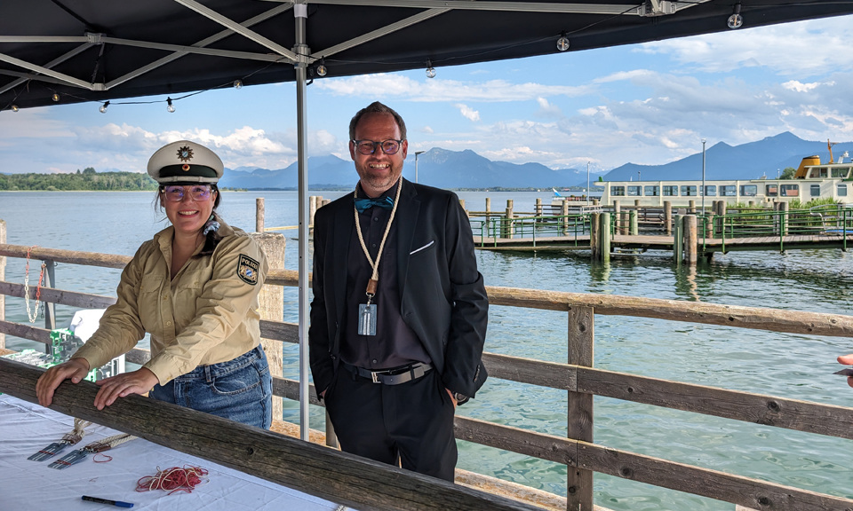 werbemax Gesch&auml;ftsf&uuml;hrer Christian H&ouml;fling mit Polizistin auf dem Steg in Prien Stock.