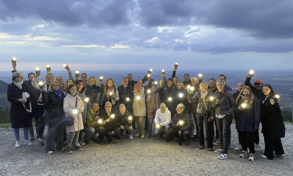 Teilnehmer der AFM Marketingtagung auf dem Berg mit eingeschalteten Troika Laternen in der Hand. 