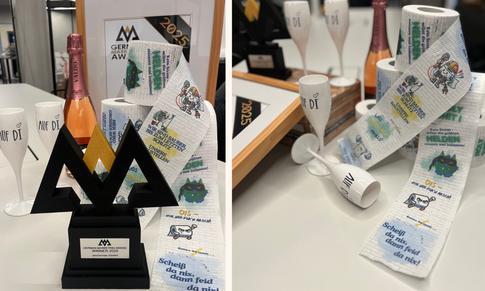German Marketing Award 2025 Trophy von werbemax neben bedrucktem Toilettenpapier mit humorvollen Spr&uuml;chen und Motiven f&uuml;r Elektro Hartinger, pr&auml;sentiert als kreatives und ausgezeichnetes Werbemittel.