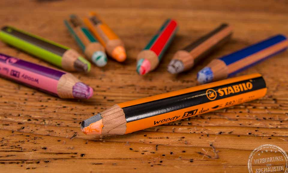 Stabilo Woody 3in1 in unterschiedlichen Farben als Merchendise auf Holztisch.