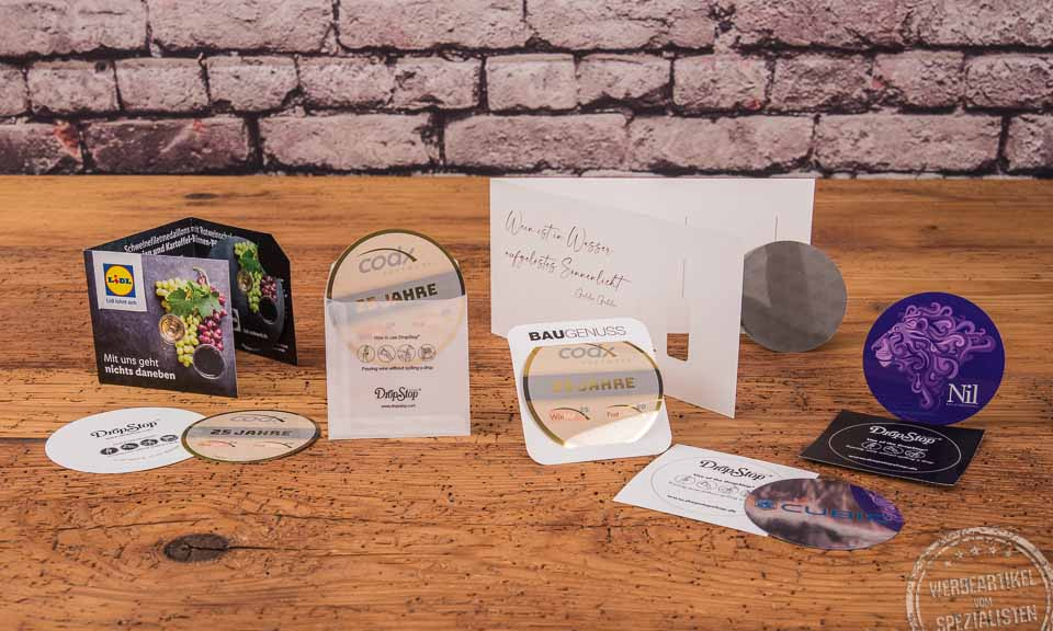Drop Stop Weinausgießer diverse Umsetzungsbeispiel mit Fotodruck und Verpackungsgestaltung auf Holztisch. 