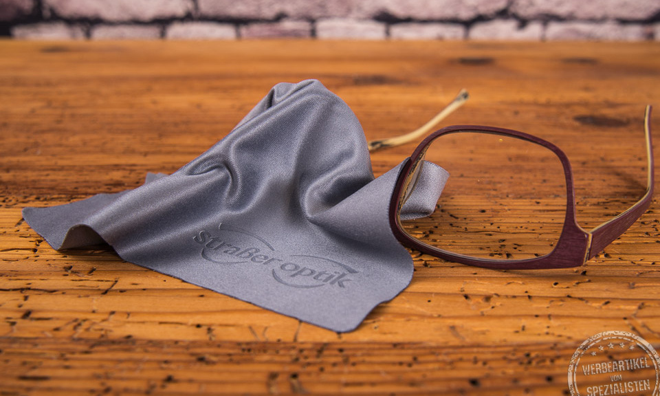 Brillenputztuch in Grau auf einer Brille