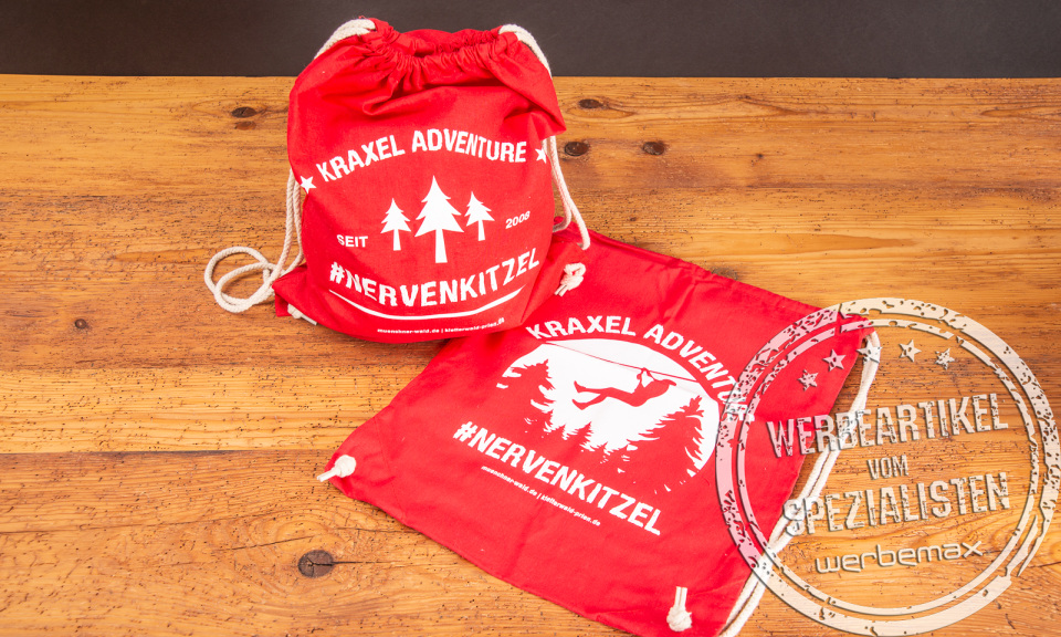 Zwei rote Matchrucksäcke mit weißem Werbedruck als Merchandiseartikel.