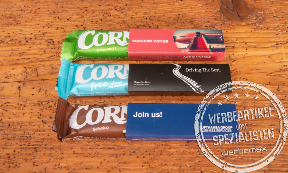 Corny Müsliriegel im bedruckten Werbeschuber als günstiger Streuartikel für Messen und Seminare